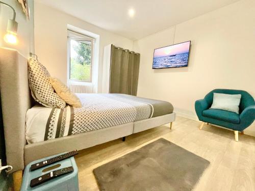 une chambre avec un lit et une chaise bleue dans l'établissement Lorient - L'escapade - Lit Queen Size - Proche Centre et Gare - Internet Haut Débit Fibre, à Lorient