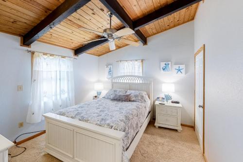 1 dormitorio con cama blanca y techo de madera en Neely's Nest en Kitty Hawk