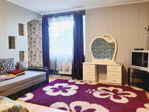 een woonkamer met een bank en een groot tapijt bij Яновского 2 in Kropyvnytsky