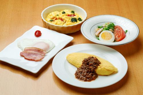 drie borden eten op een houten tafel bij Choyo Resort Hotel in Kamikawa