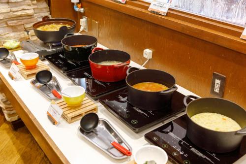 een fornuis met vier potten eten erop bij Choyo Resort Hotel in Kamikawa