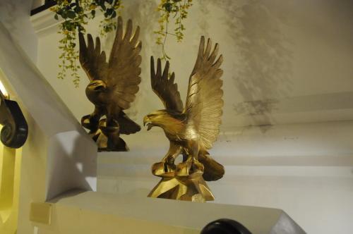 two statues of two birds sitting on a shelf at Hotel Veneto De Vigan in Vigan