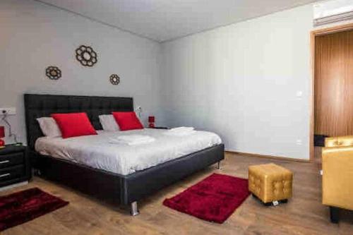1 dormitorio con 1 cama grande con almohadas rojas en Viana do Castelo - Amonde Village - Casa L - Disfrute da Natureza, en Amonde