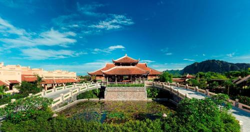a resort with a pond in front of a building at Emeralda Resort Ninh Binh in Ninh Binh