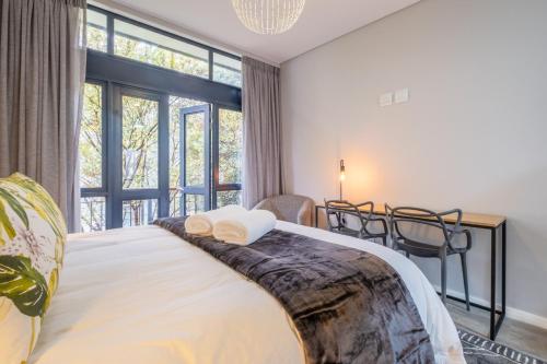 a bedroom with a bed and a large window at Lemon Rind - 16 Eikehoff in Stellenbosch