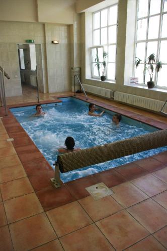 three people swimming in a swimming pool at Sanatorija ,,Tulpės" in Birštonas