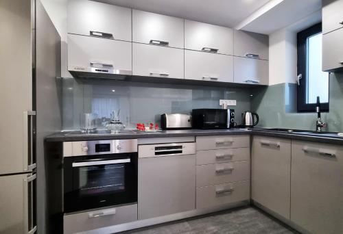a kitchen with white cabinets and a stove top oven at The Butterfly in Sângeorgiu de Mureș
