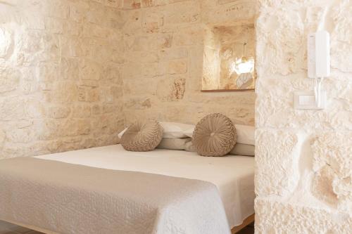 um quarto com uma cama numa parede de pedra em Vico Monte II - Casa Vacanze em Ceglie Messapica