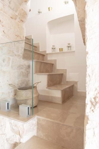 a staircase in a room with a stone wall at Vico Monte II - Maison typique des Pouilles in Ceglie Messapica