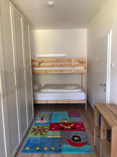 a small bedroom with a bunk bed and a rug at Apartment HUGO in Bad Kleinkirchheim