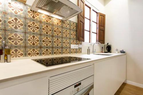 uma cozinha com um lavatório e uma parede de azulejos em Cream homes La Rambla, TURISMO DE INTERIOR em Palma de Maiorca