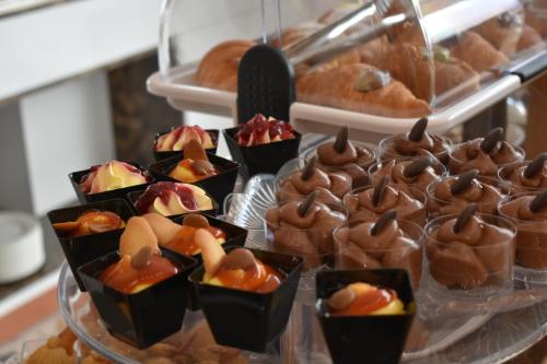a tray of chocolatecovered desserts on a counter with pastries at Giulia Albérgo Hotel in Durrës