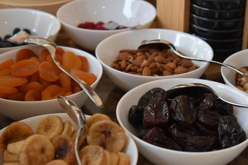 a table topped with bowls of nuts and dried fruits at Giulia Albérgo Hotel in Durrës