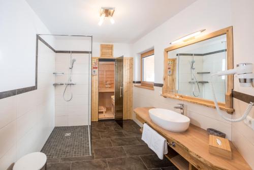 a bathroom with a shower and a toilet and a sink at Kirchgassers Landhäusl in Ramsau am Dachstein