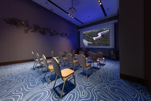 a conference room with a bunch of chairs and a screen at Swissôtel Wellness Resort Alatau Almaty in Almaty
