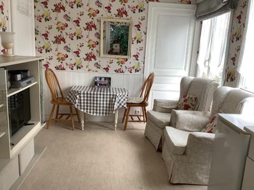 un salon avec une table et des chaises dans l'établissement Le Petit Chalet, à Bagnoles-de-l'Orne