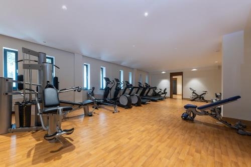 a gym with a row of exercise bikes and treadmills at Swissôtel Wellness Resort Alatau Almaty in Almaty