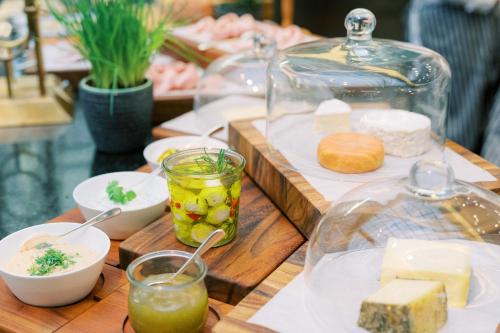 a wooden table topped with plates of cheese and drinks at Park Hyatt Vienna in Vienna