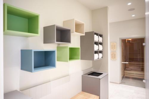 a kitchen with white walls and green and gray cabinets at Hotel Maxlhaid in Wels