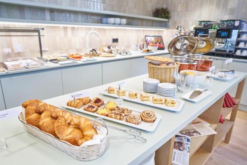 a bakery with several trays of pastries on a table at Hotel Maxlhaid in Wels