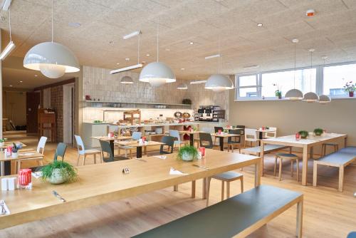 a restaurant with tables and chairs and a cafeteria at Hotel Maxlhaid in Wels