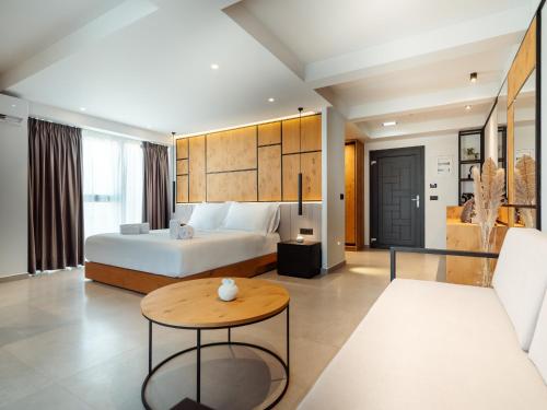een slaapkamer met een bed, een tafel en een bank bij Sigma59 Dine & Stay in Chersonissos
