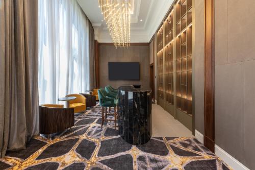 a lobby with a table and chairs and a television at Swissôtel Wellness Resort Alatau Almaty in Almaty