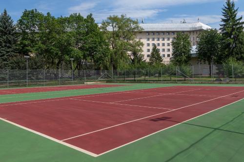 a tennis court in front of a building at Swissôtel Wellness Resort Alatau Almaty in Almaty