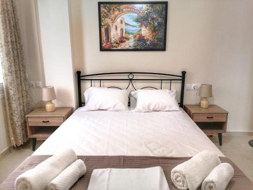 sypialnia z dużym białym łóżkiem z 2 stolikami nocnymi w obiekcie Alex Apartment, Cozy Place in Heraklion Center w Heraklionie