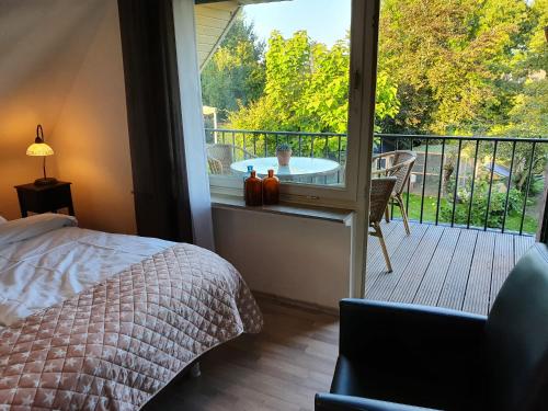 a bedroom with a bed and a balcony with a table at B&B Die Herrlichkeit in Lage