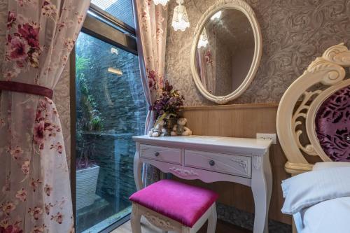 a dressing table with a pink stool and a mirror at 花蓮晨風星語民宿Sun Star B&B in Jian