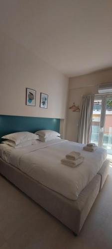 a large white bed in a room with a window at The Convo Athens Riviera in Athens