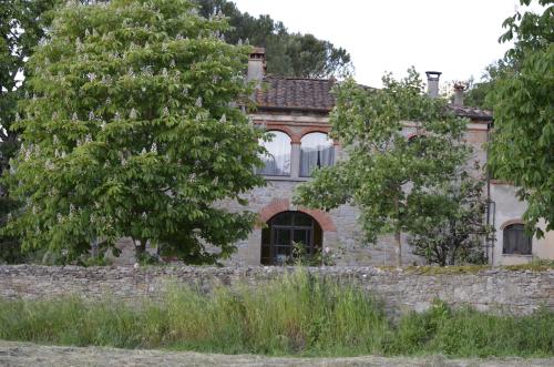 an old stone house behind a stone wall at Villa La Ginestra - Charming Country Home in Capolona