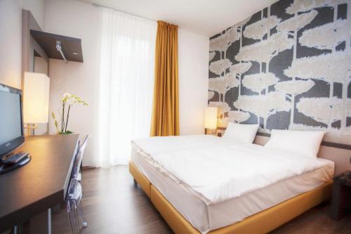 a bedroom with a bed and a desk with a computer at Hotel Internazionale Bellinzona in Bellinzona