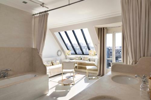 a living room with a tub and a couch at Hôtel de Banville in Paris