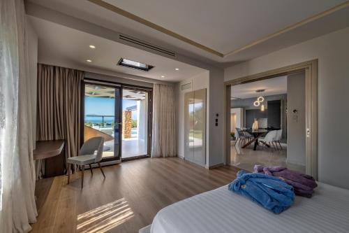 sypialnia z łóżkiem i widokiem na ocean w obiekcie Iakovakis Suites & Spa w mieście Koropi