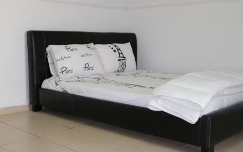 a black bed with white sheets and pillows on it at Tsangaris House in Action in Limassol