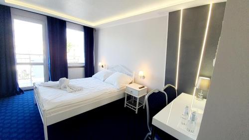ein Hotelzimmer mit einem Bett und zwei Fenstern in der Unterkunft Hotel Imperium in Pionki