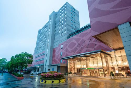 a building on a street with flowers in front of it at Holiday Inn Nanjing Aqua City by IHG in Nanjing