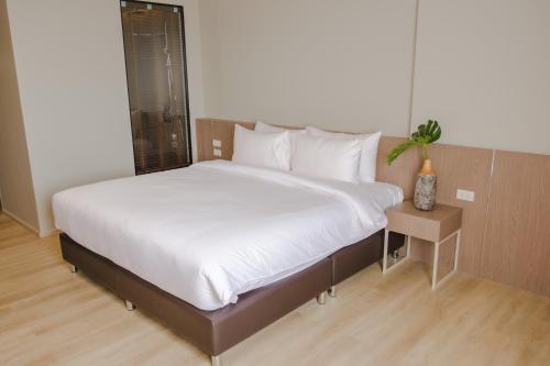 a bedroom with a large bed with white sheets at The Rise Suites Hotel, Chiang Mai - SHA Extra Plus in Chiang Mai