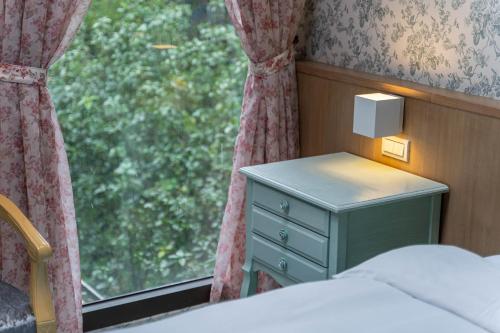 a bedroom with a bed and a window with a night stand at 花蓮晨風星語民宿Sun Star B&B in Jian