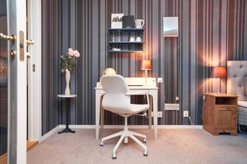 an office with a white chair and a desk at Björkbackens Karaktärshotell in Vimmerby