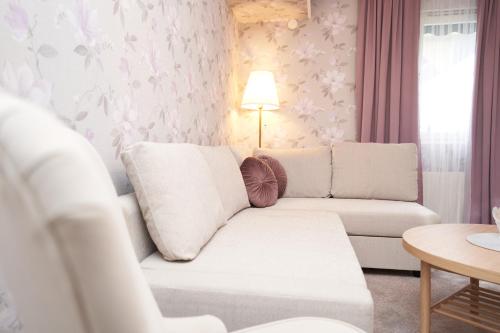 a living room with a white couch and a table at Björkbackens Karaktärshotell in Vimmerby