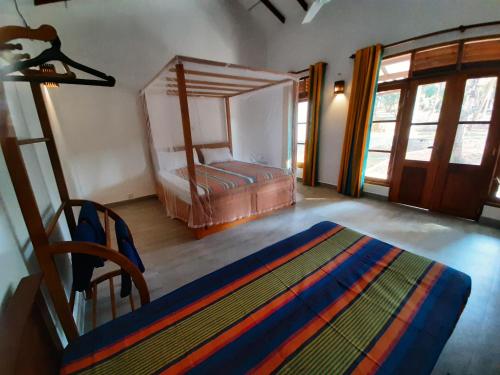 a bedroom with a bed and a chair in a room at Jackland Holiday Cabanas in Demanhandiya