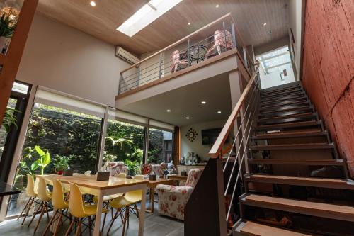 a dining room with a staircase and a table with yellow chairs at 花蓮晨風星語民宿Sun Star B&B in Jian