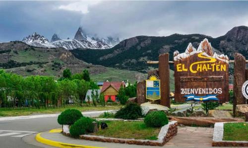 a sign for the el chion resort with mountains in the background at NB Mountain aparts El Chalten in El Chalten