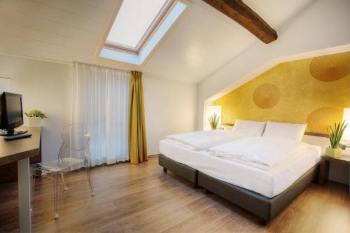 a bedroom with a large bed and a skylight at Hotel Internazionale Bellinzona in Bellinzona