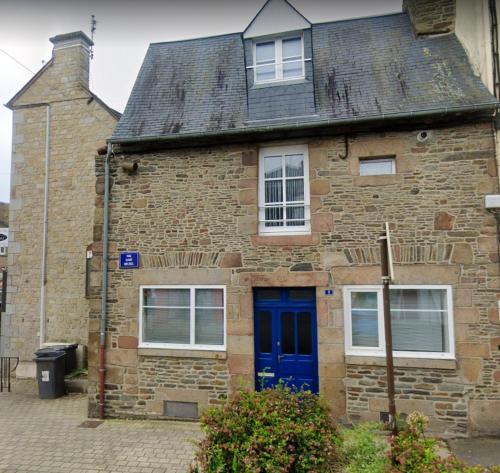 une vieille maison en briques avec une porte bleue dans l'établissement Maison charmante - Pontorson + Parking, à Pontorson
