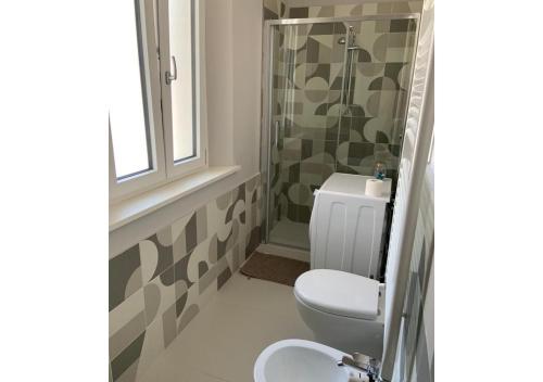 een badkamer met een toilet, een douche en een wastafel bij Delizioso appartamento in villa al mare in Pesaro