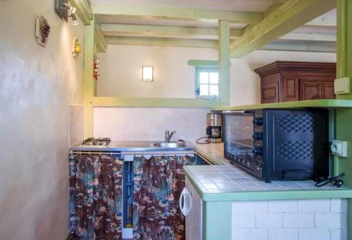 une cuisine avec un évier et une cuisinière four supérieur dans l'établissement Maison charmante à Landevieille avec jardin clos, à Landevieille